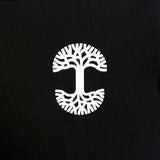 Detailed close up image of black tee with white(to start) UV activated Oaklandish tree logo on wearer's left chest.