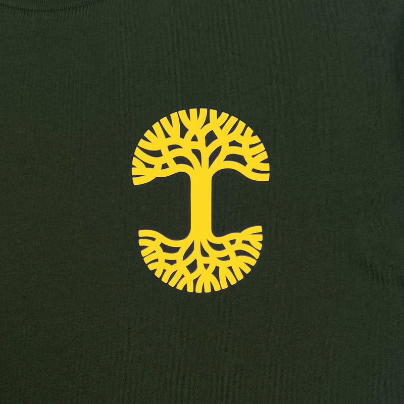 Detailed close up image of Forest tee with yellow UV activated Oaklandish tree logo on wearer's left chest.