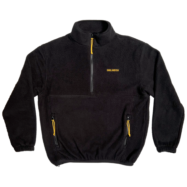 Black polar fleece pullover with 1/2 zip, yellow zip pulls two pockets, and yellow Oaklandish wordmark on the wearer's left chest.