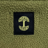 Detailed close up of black satin patch with green Oaklandish tree logo on back of green polar fleece.
