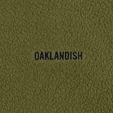 Close up of black embroidered Oaklandish wordmark on green polar fleece.