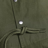 Close up of front snaps and drawstrings on green cotton jacket.