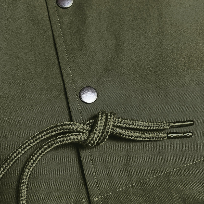 Close up of front snaps and drawstrings on green cotton jacket.