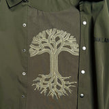 Detailed close-up of large white Oaklandish tree logo on the inside back panel of a olive green coaches jacket.