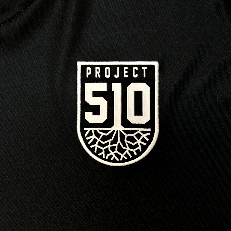 Detail close up of black Meyba jersey Project 510 crest on wearer's left chest.