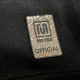 Detail close up of Meyba logo at hem of black Project 510 x Meyba Jersey.