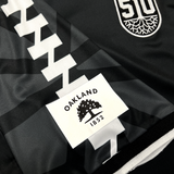 Detail close up of black Meyba jersey Project 510 crest on wearer's left chest and Oakland Flag in Black and white on right sleeve.