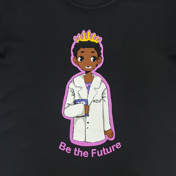 Close-up of a crowned Royal Scientist boy dressed as a scientist and a “Be The Future” wordmark on a black t-shirt.