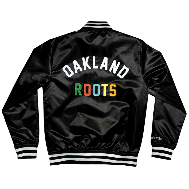 The backside of Mitchell & Ness black satin jacket with large centered Oakland Roots wordmark.