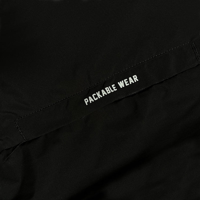 Close-up of “Packable Wear” wordmark on the black side of a packing pouch for a black Roots SC zip-up hoodie.