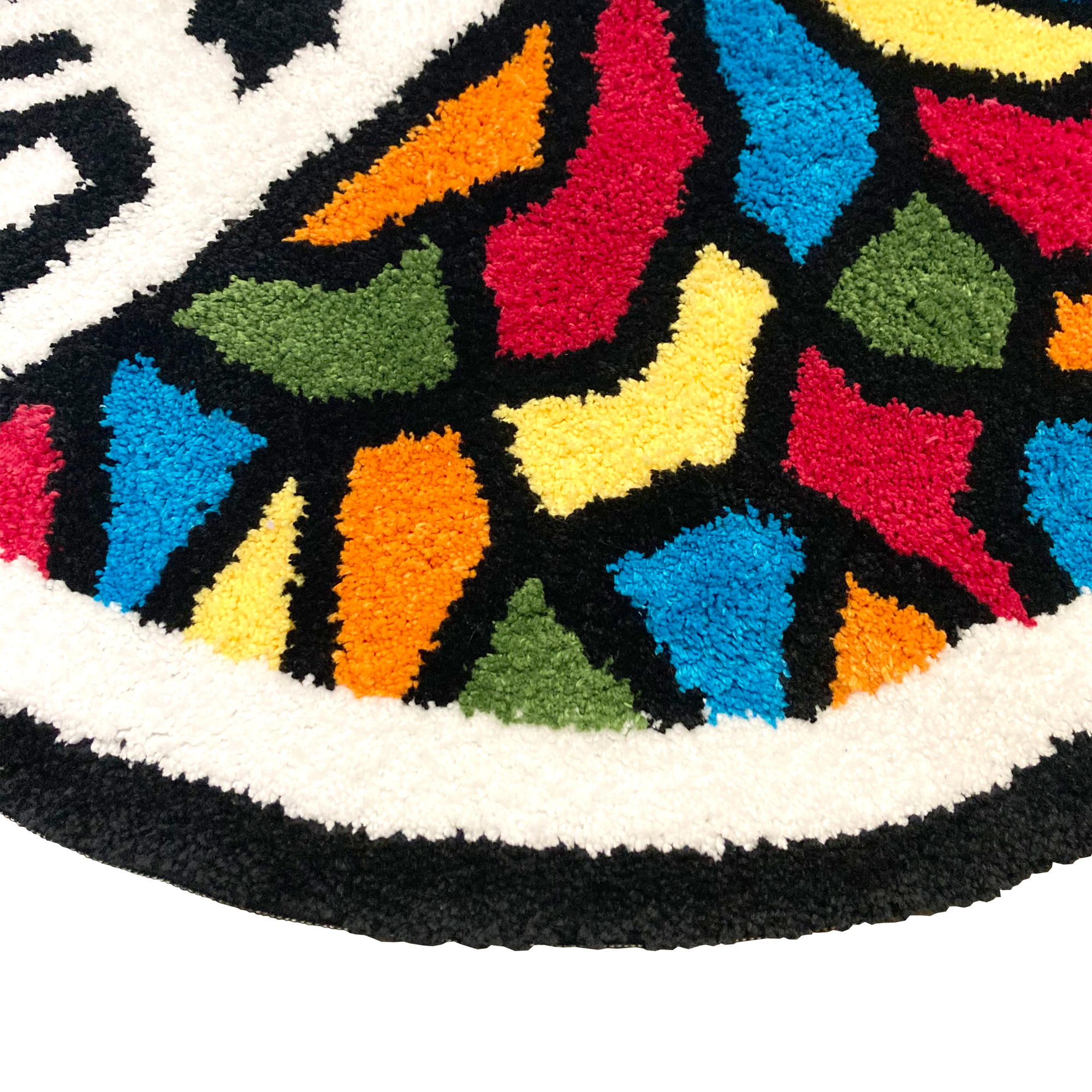 A close-up of the Oakland Roots SC Logo Rug from Oakland Roots SC on a black background. This circular area rug showcases vibrant, abstract geometric shapes in red, yellow, blue, green, and orange. The design is accentuated with a thick white border.