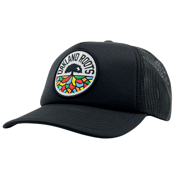 Side view of black Mitchell & Ness snapback truckers cap with full-color Roots SC logo.