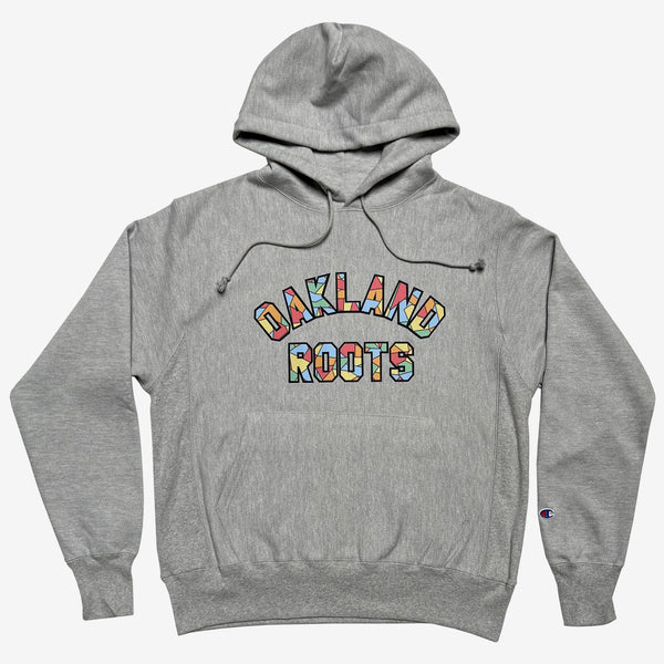 Grey pullover hoodie with Oakland Roots applique wordmark in rainbow capital letters.
