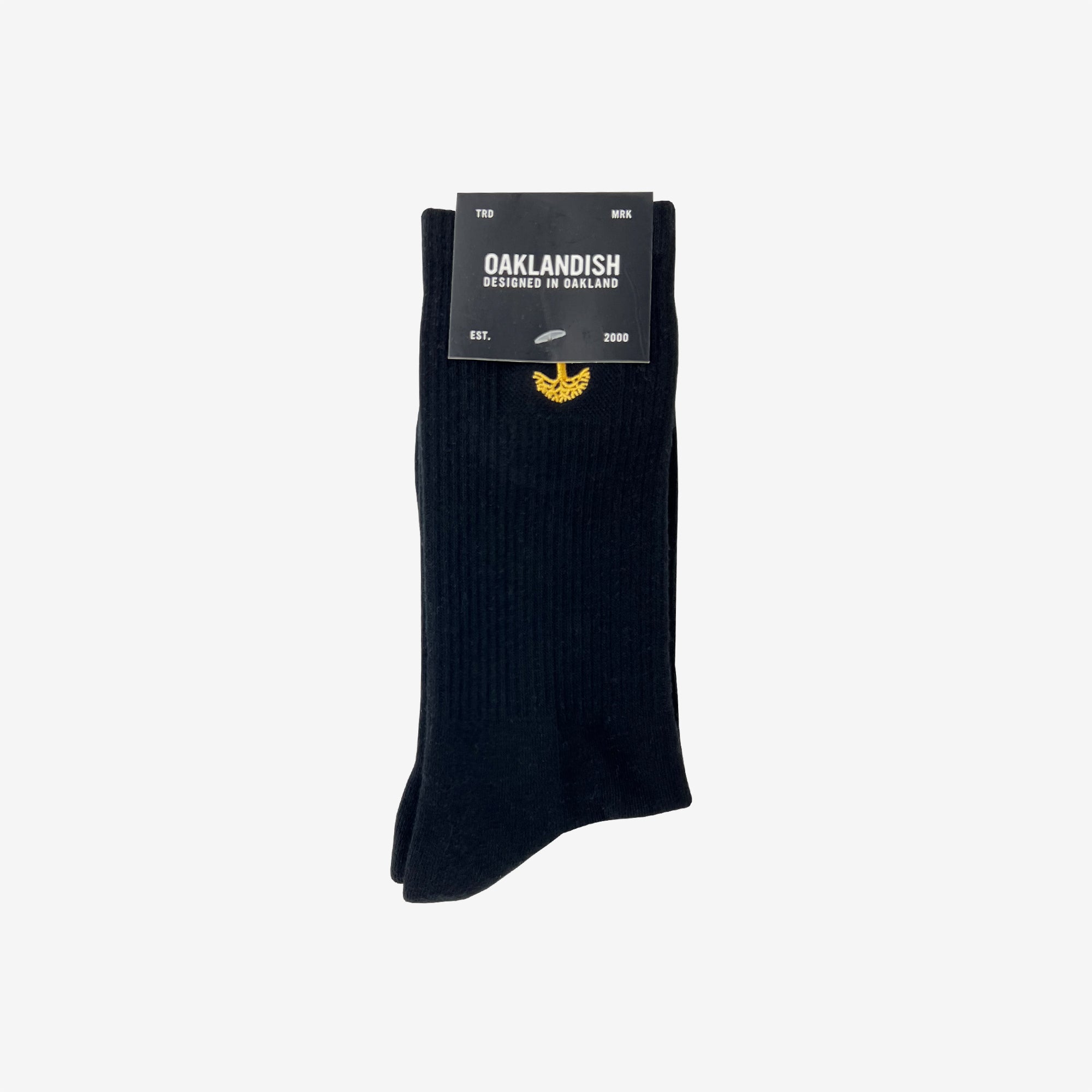 High-cut men's black crew socks with gold embroidered Oaklandish logo at the top wrapped in Oaklandish retail packaging.