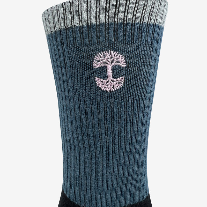 Close up of embroidered pink Oaklandish logo at the top of color block crew socks.