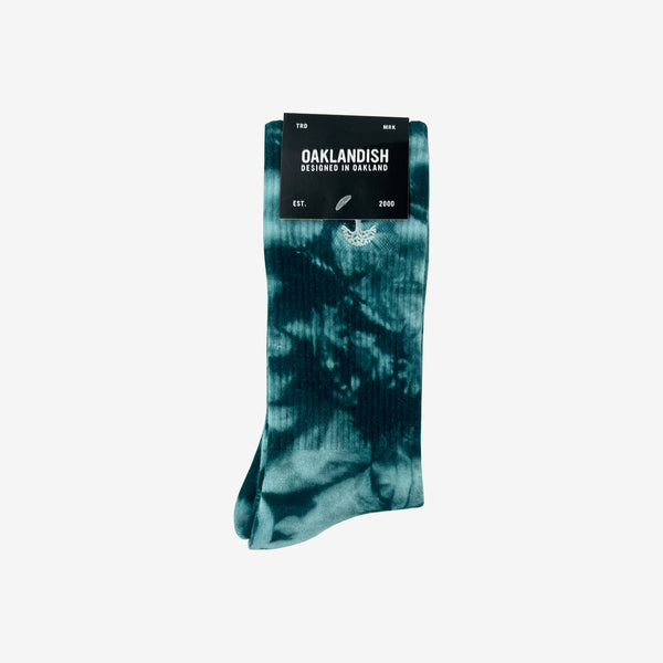 High-cut light and dark blue crew socks with an embroidered Oak logo detail folded in Oaklandish retail packaging.