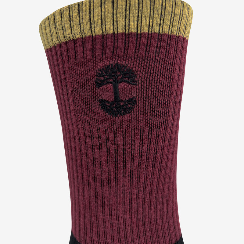 Close up of embroidered Oaklandish logo at the top of color block (black, maroon & brown) crew socks.