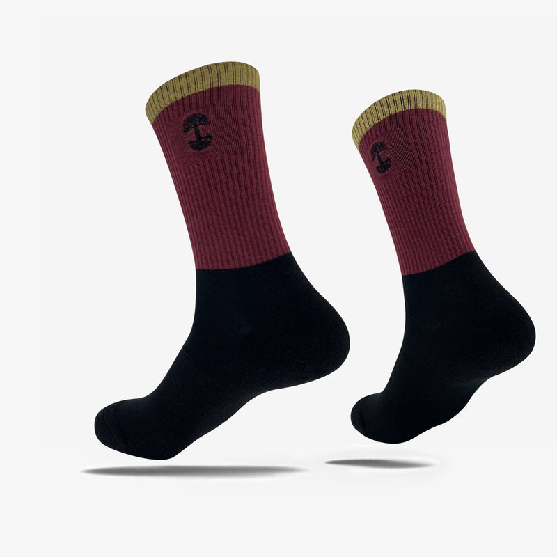 High-cut color blocked black, maroon, and brown crew socks with an embroidered Oaklandish logo at the top.