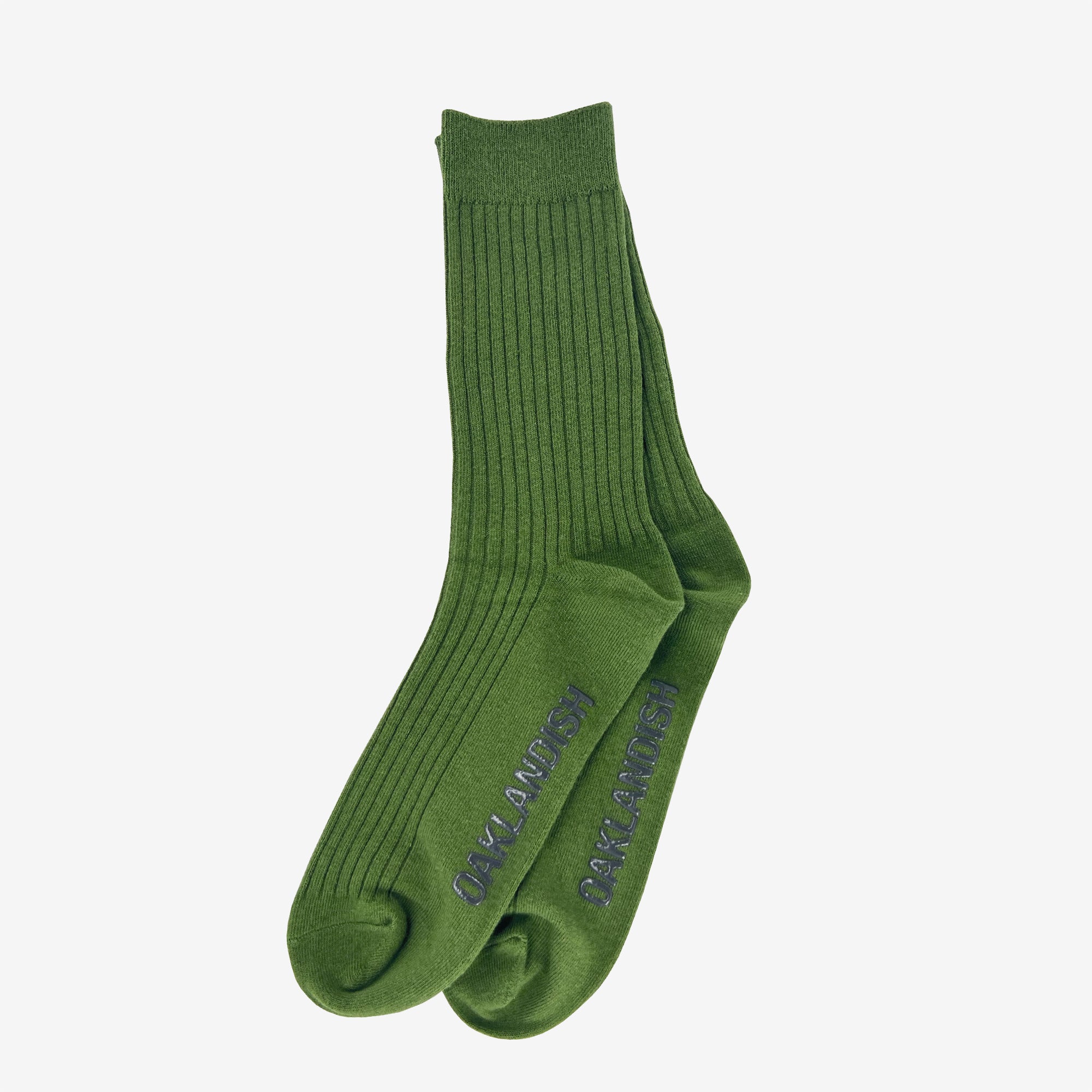 A pair of green Grip Crew Socks by Oaklandish, featuring "BANKAI INVANZO" vertically printed in blue along the outer sides. These one-size-fits-most socks are neatly laid out flat on a plain white background, showcasing their stylish design.
