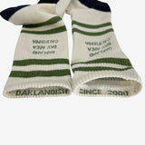 View of inside of socks to expose wordmarks Oaklandish and Since 2000, one on each rim in green.