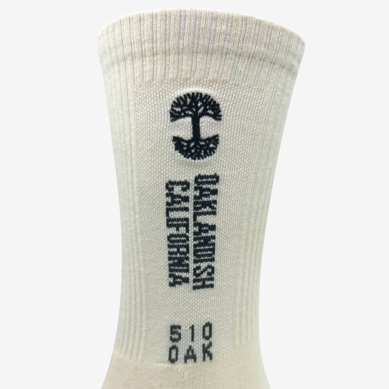 Close up of words Oaklandish California, 510 Oak & Tree Logo on a white crew sock.