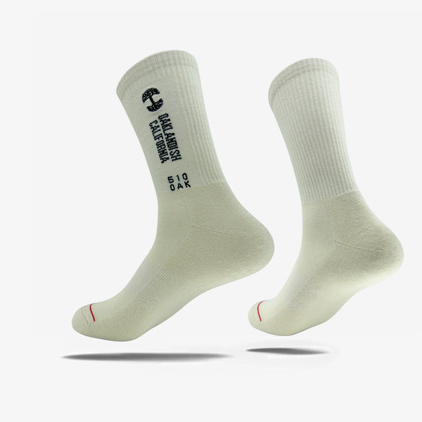 High-cut white crew socks with words Oaklandish California, 510 Oak, and Oaklandish Tree Logo on one side of each sock. 