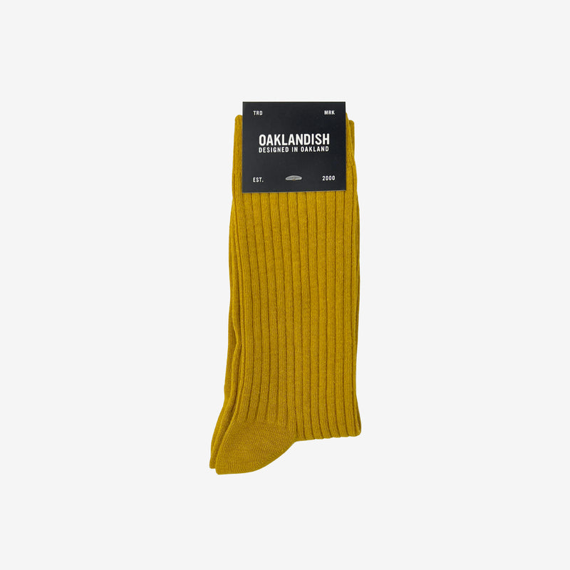 High cut yellow men's crew socks  folded in Oaklandish retail packaging.