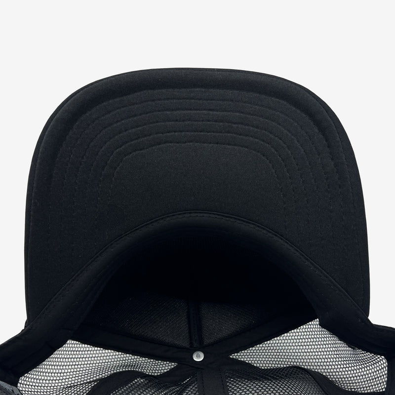 Under brim and inside of black low profile trucker hat.