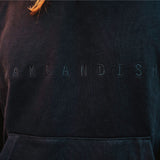Detailed close-up of embroidered Oaklandish wordmark on a black hoodie worn by a man.