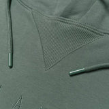 Detailed close up of triangle ribbing patch at collar of army standard pullover sweatshirt with metal drawcord tips.
