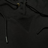Detailed close up of triangle ribbing patch at collar of black pullover hoodie with metal drawcord tips.