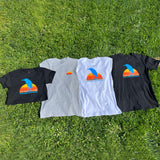 The four styles of Oaklandish Sun Heron T-shirts lying flat on the grass.