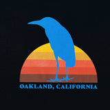Detailed close up of Sun Heron graphic and Oakland California wordmark on a black t-shirt.