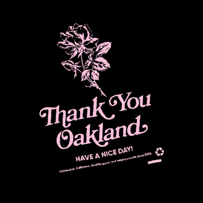 Close up of a hand drawn pink flower with the words “Thank-You Oakland. Have a Nice Day” on a black t-shirt.