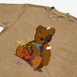 Close-up of artistically painted battered teddy bear with yellow and red paint splatter on a brown t-shirt.