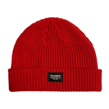 Close-up of Oaklandish square patch on the front cuff of red ribbed knit beanie.