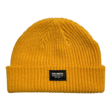Gold short knit beanie with Oaklandish square patch on the front cuff.