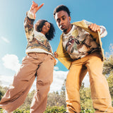 Man and woman wearing crewneck Oaklandish sweatshirts with wood duck all over print.
