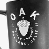 Close up of the graphic saying “OAK People, Purpose, Oakland Calif” on the stoneware mug.