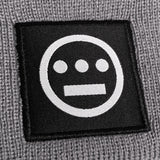 Close up of black and white hiero hip-hop logo patch on the cuff of a grey beanie.