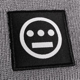Close up of black and white hiero hip-hop logo patch on the cuff of a grey beanie.