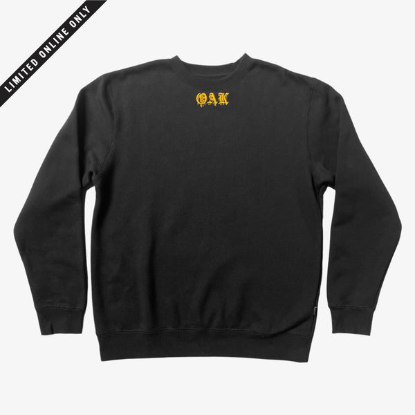 Black crew neck t-shirt with gold embroidered OAK in bleeding old-style font. 