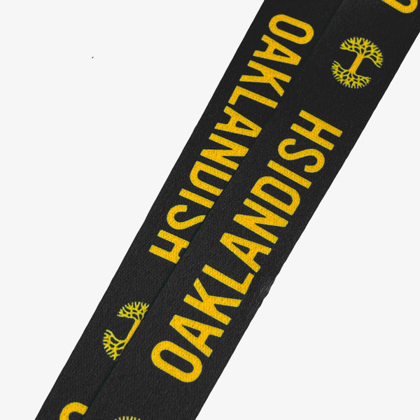 Yellow Oaklandish word mark and tree logo on a black lanyard.