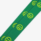 Detailed close-up of yellow Hieroglyphics hip-hop logo on repeat on a green quick release lanyard. 
