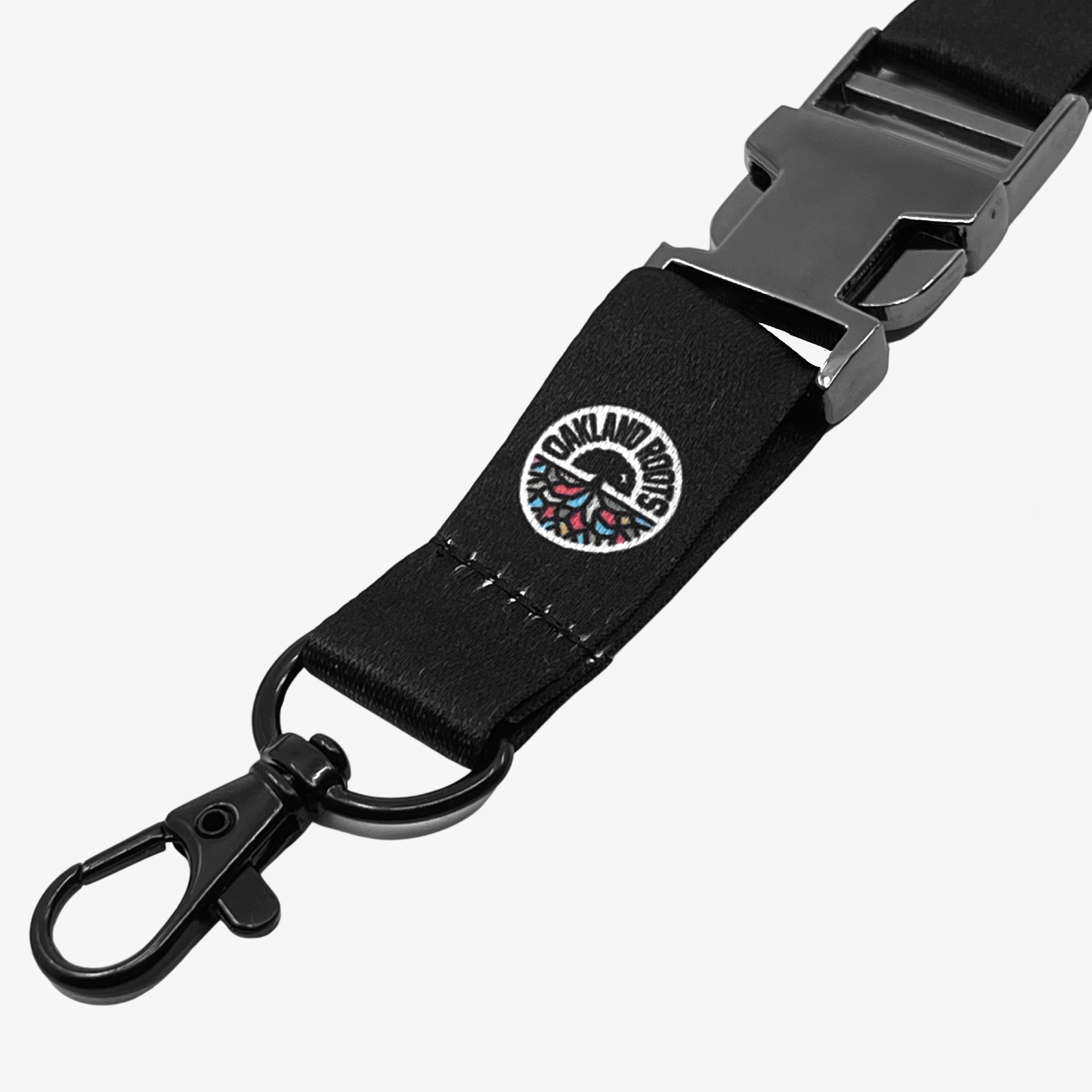 Close up detachable clip with color round Roots SC logo on a black lanyard.