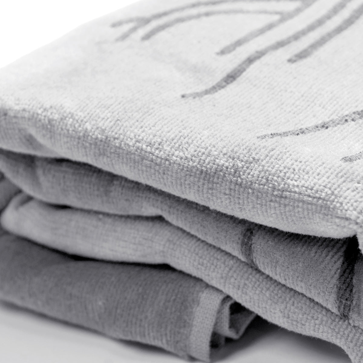 Very detailed close up of a folded oversized silver-grey beach towel.