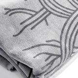 Detailed close up of Oaklandish logo outlines on an oversized silver-grey beach towel.