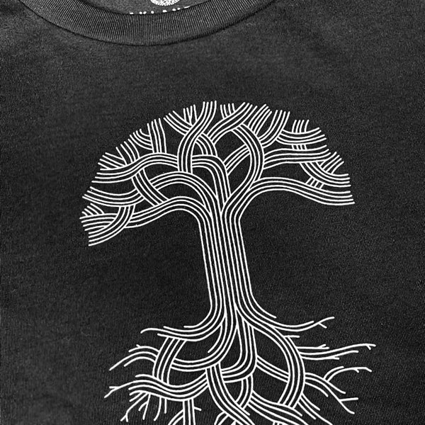 Close-up of white classic Oaklandish tree logo and wordmark on chest of a black women’s cut t-shirt.