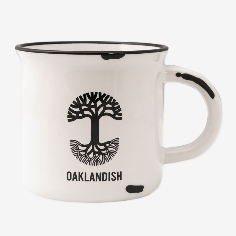 Back view of a white stoneware coffee mug featuring a retro style black Oaklandish tree logo on the backside.