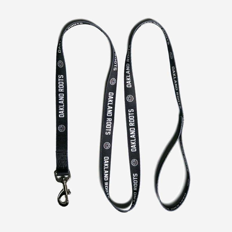 Black dog leash with white OAKLAND ROOTS wordmark and round full-color logo on repeat.